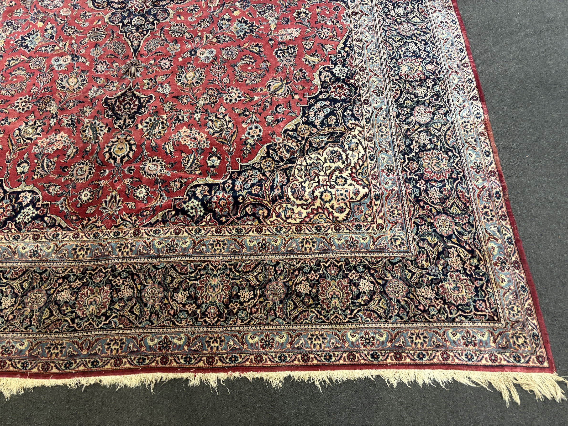 A Persian Kashan carpet with central medallion on a foliate red ground, multi bordered, 430 x 315cm